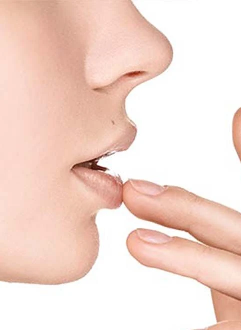 Seitliche Ansicht von Lippen mit Finger an der Unterlippe